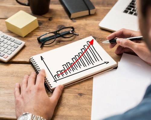 Businessman drawing a growing chart on a paper notebook